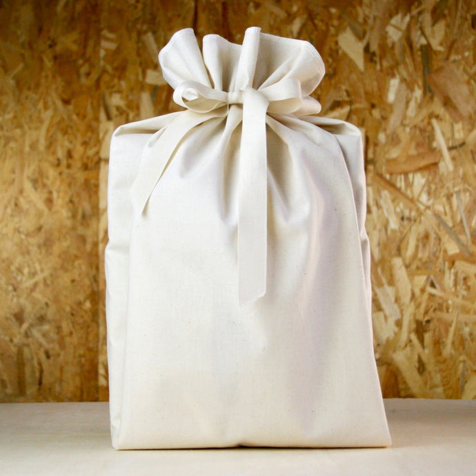 Emballage cadeau en tissu 100% coton 100% réutilisable 100% français tissu écru taille M fond bois créateur de lien révolutionnons ensemble le monde de l'emballage papier cadeau furoshiki alternative